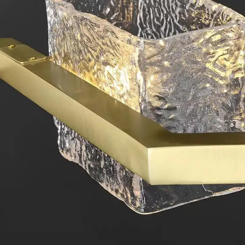 Modern gold crystal ceiling chandelier with gold-toned rectangular bar featuring textured glass and swirling patterns