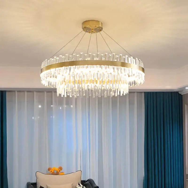 Modern gold crystal chandelier lighting fixture with decorbites circular metal frame and clear crystal prisms for dining room