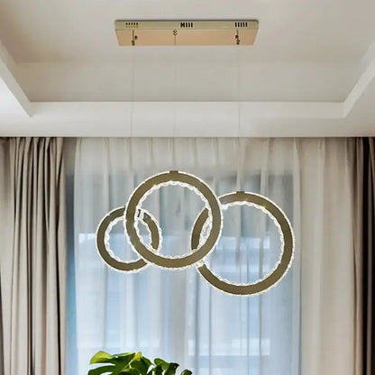 Modern gold crystal circle led pendant chandelier with three interlocking rings and sparkling crystal accents for dining room decorbites
