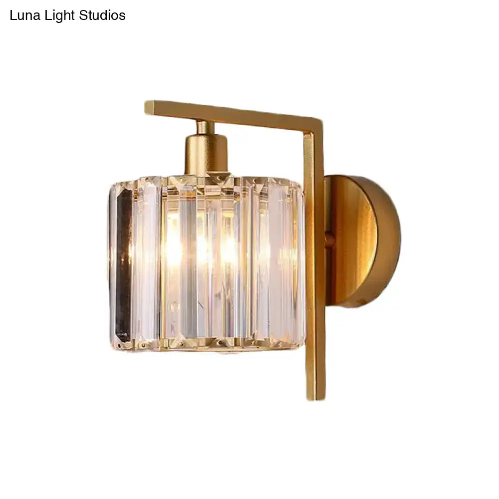 Modern gold wall sconce featuring a cylindrical crystal column shade with vertical facets for bedroom lighting