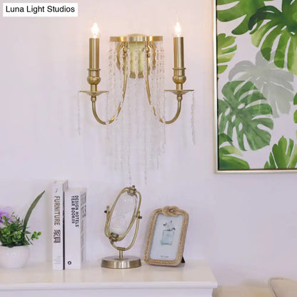 Modern gold-toned crystal corridor wall lamp with two candle-like arms and clear glass bead accents for bedroom lighting