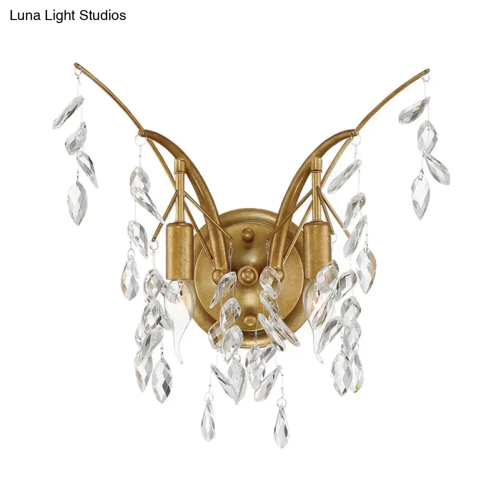 Modern gold wall sconce with two curved arms and clear crystal drop accents for living room lighting