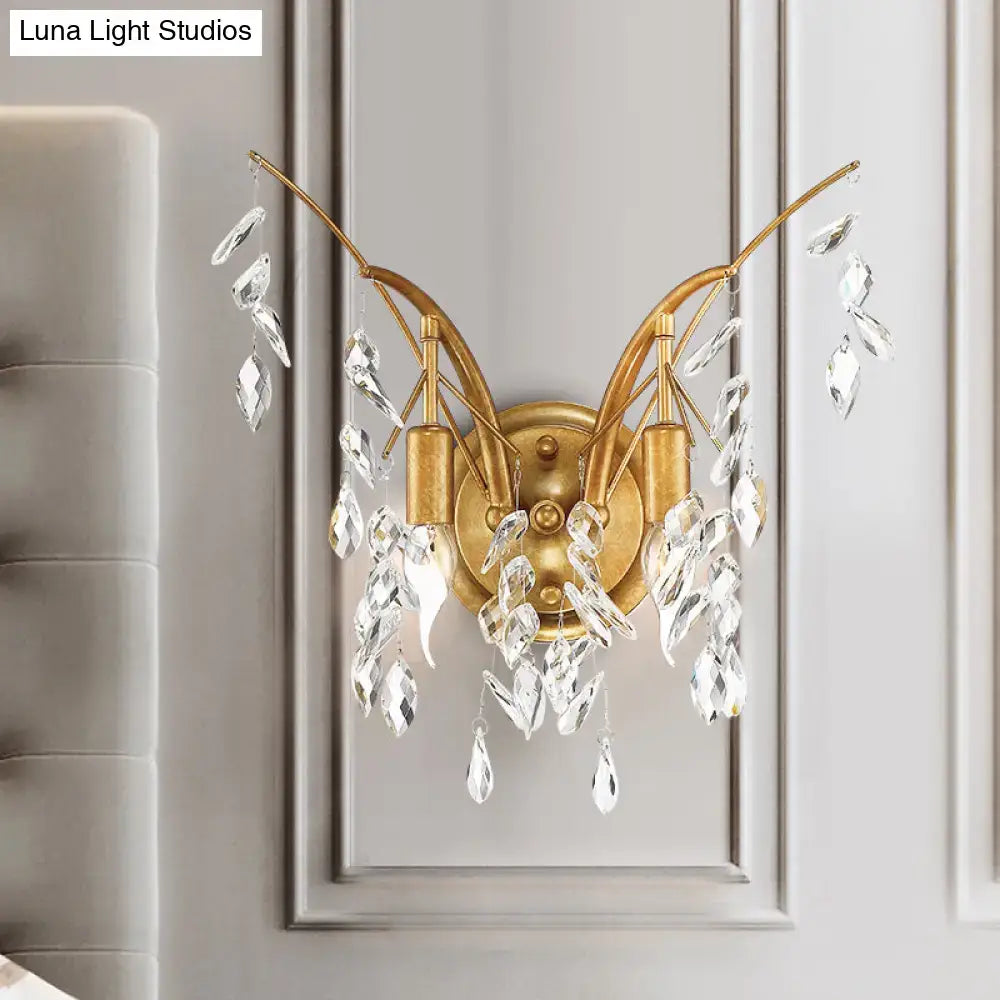 Modern gold wall sconce with elegant curved arms and cascading clear crystal droplets for living room lighting