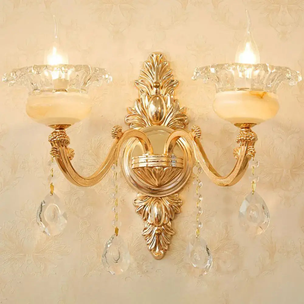 Modern gold crystal droplet wall mount light featuring two candle-style lights with glass teardrop accents