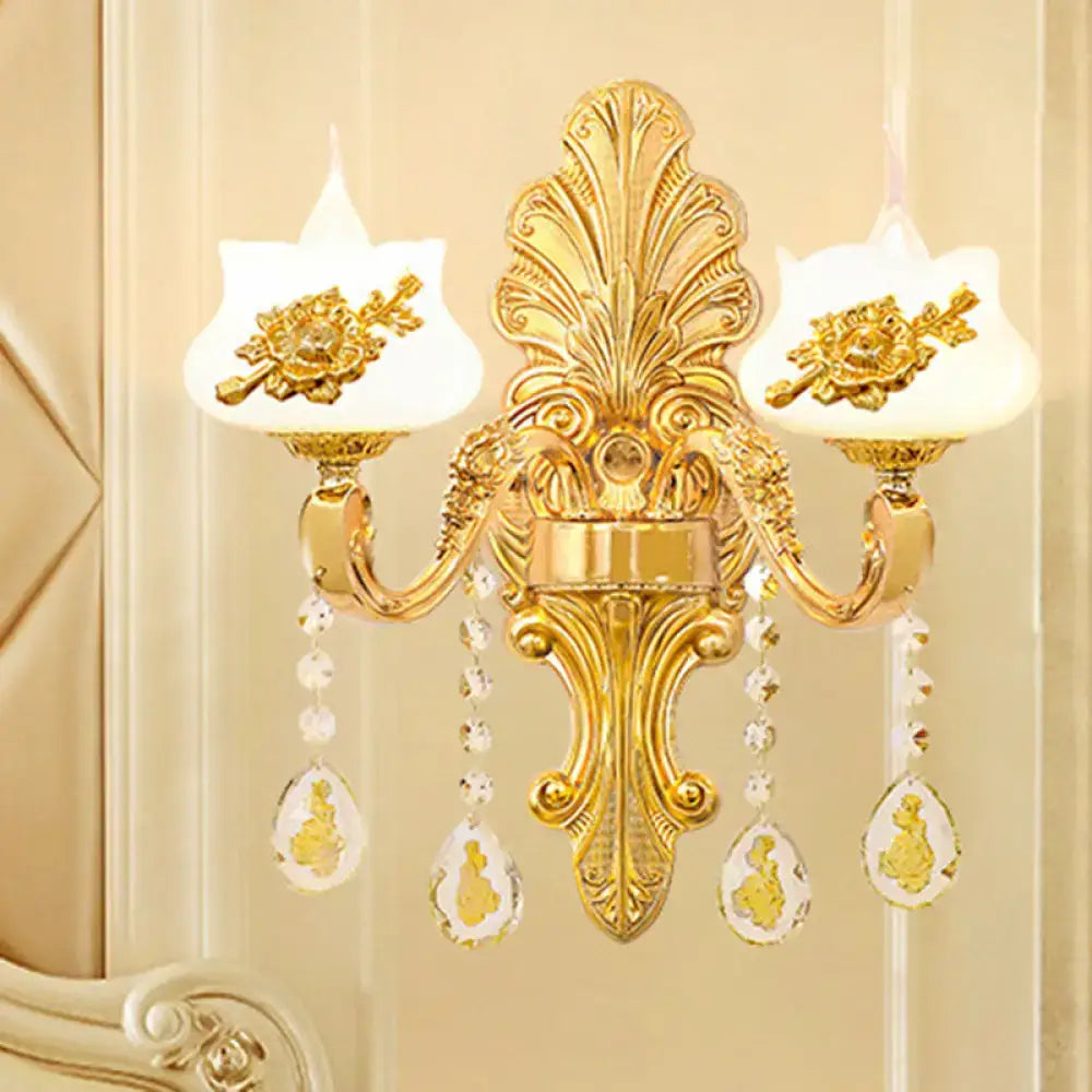 Modern gold crystal droplet wall mount light with two white glass shades and floral embellishments for bedroom use