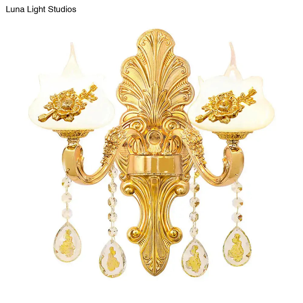 Modern gold wall mount light featuring two candle-style frosted glass shades with crystal droplet pendants