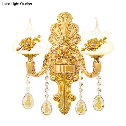 Modern gold wall mount light featuring two candle-style frosted glass shades with crystal droplet pendants