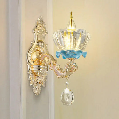 Modern gold wall mount light with ornate crystal droplet design and blue enamel accents for bedroom use