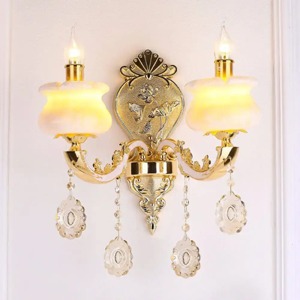 Modern gold wall mount light featuring ornate design with frosted glass shades and crystal droplet accents for bedroom use