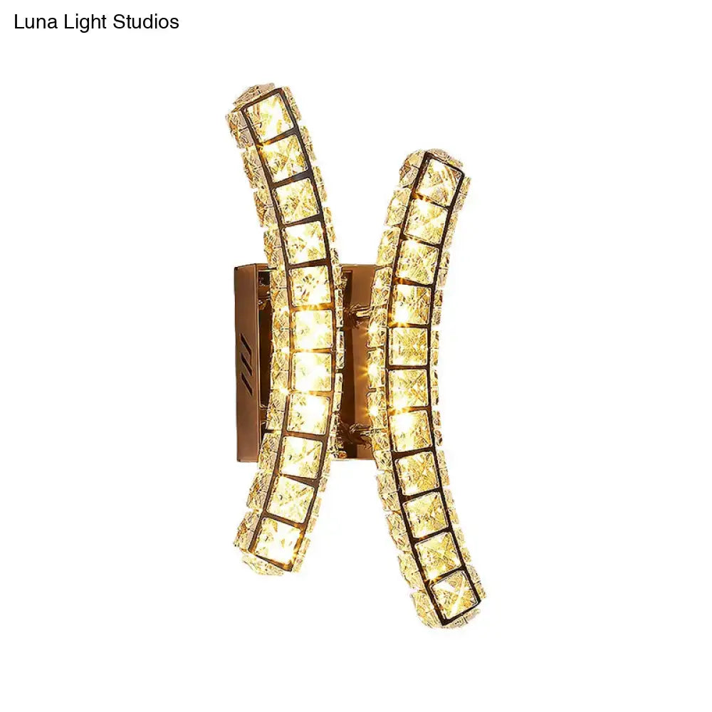 Modern gold wall sconce with crystal dual curved arms forming an x-shape for warm and white bedroom light