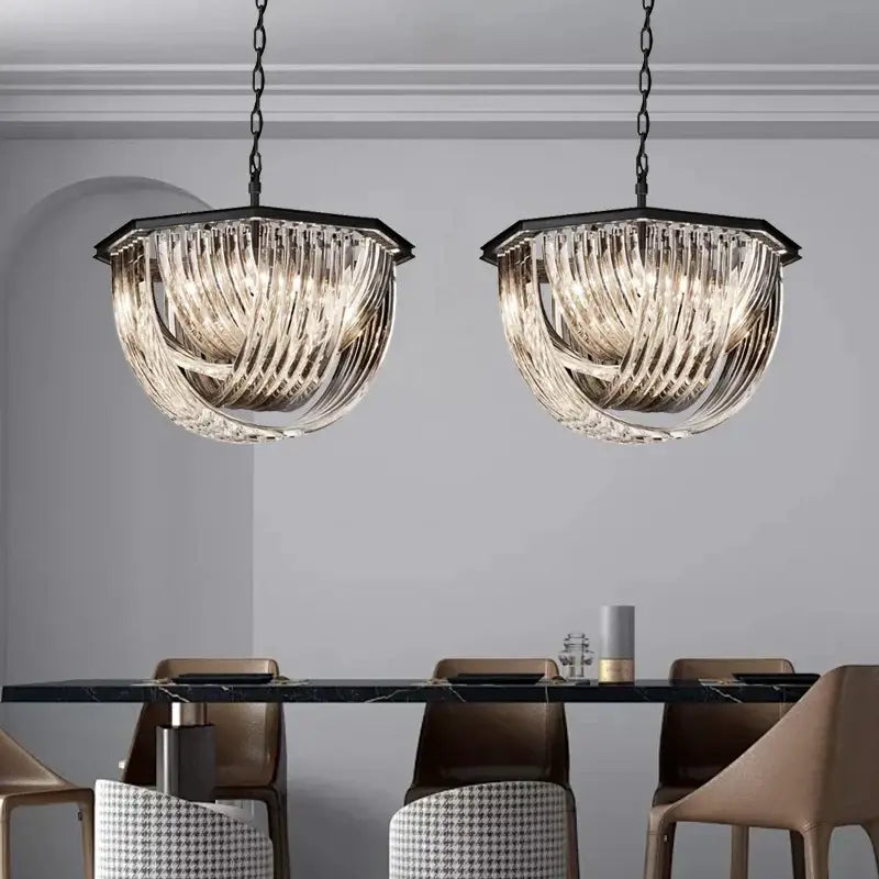 Two elegant black-framed decorbites crystal glass pendant lights with twisted glass shades hang above a dining table