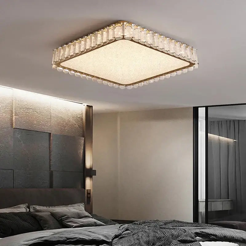 Modern gold crystal led ceiling light with square gold-toned frame and beaded edge emitting warm ambient light decorbites crystal led