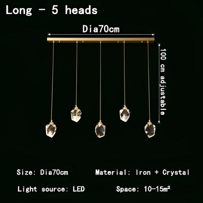 A modern gold crystal led pendant light featuring five faceted crystal pendants on a sleek brass bar for dining room
