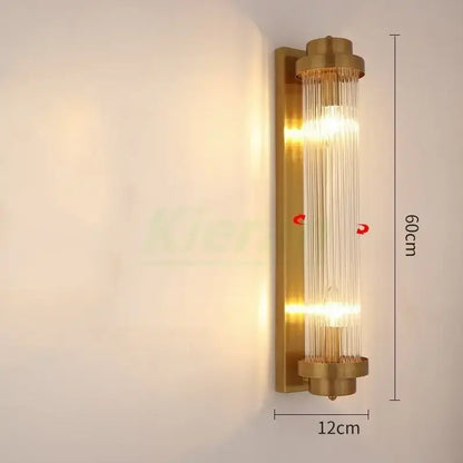 Modern gold crystal led wall lamp with brass finish and vertical glass rods emitting warm glowing light decorbites crystal led wall