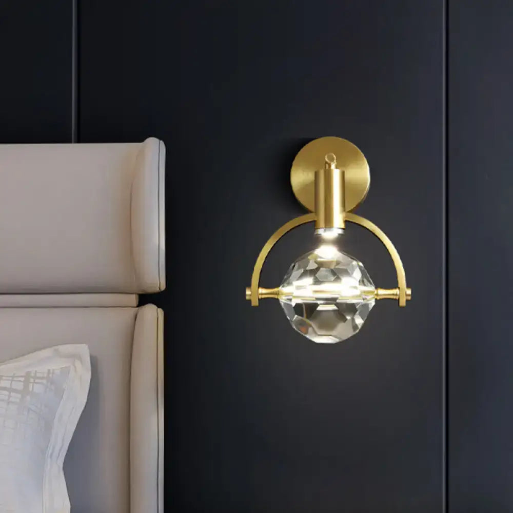 Modern gold led wall lamp featuring a faceted crystal globe suspended by an arched metal frame bulb base