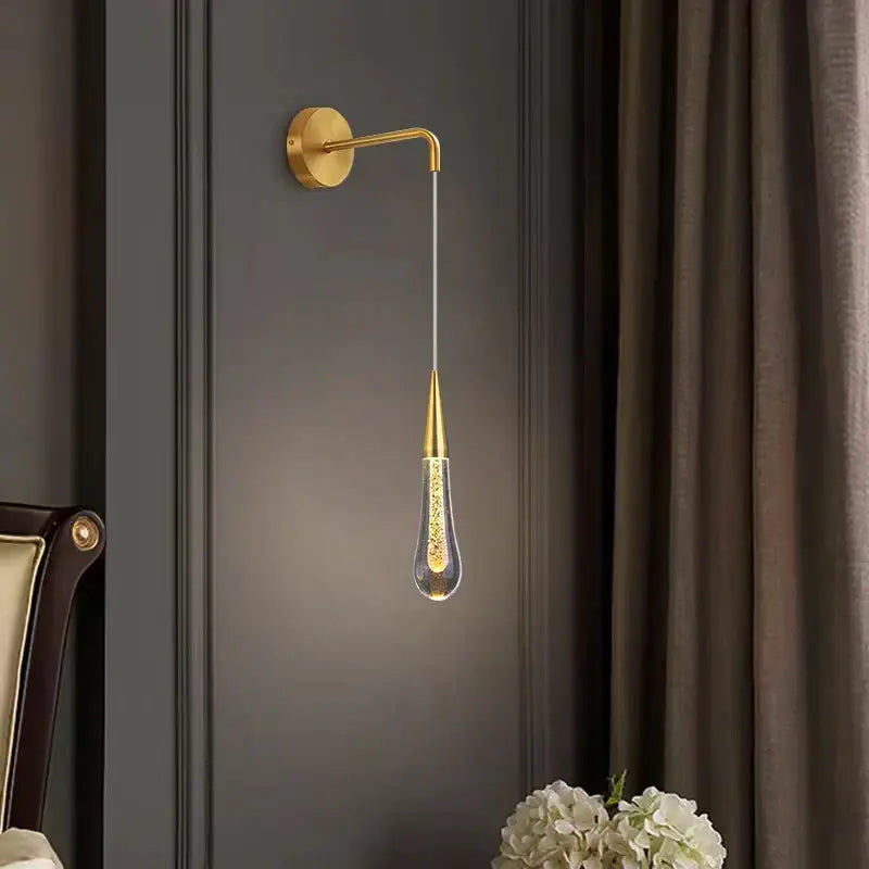 Gold-toned modern wall lamp with teardrop glass pendant and golden speckles in decorbites crystal led wall design