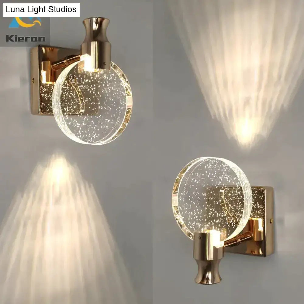 Modern gold crystal led wall lamp featuring a gold-toned wall sconce with a clear globe filled with sparkling particles