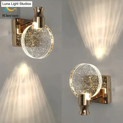 Modern gold crystal led wall lamp featuring a gold-toned wall sconce with a clear globe filled with sparkling particles