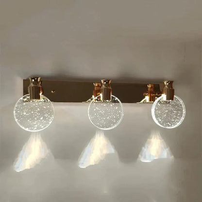 Modern gold crystal led wall lamp with three circular glass globes filled with sparkling particles for bathroom use
