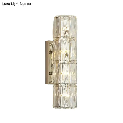 Modern gold crystal linear wall light with clear faceted segments and brushed brass backplate for dining room use