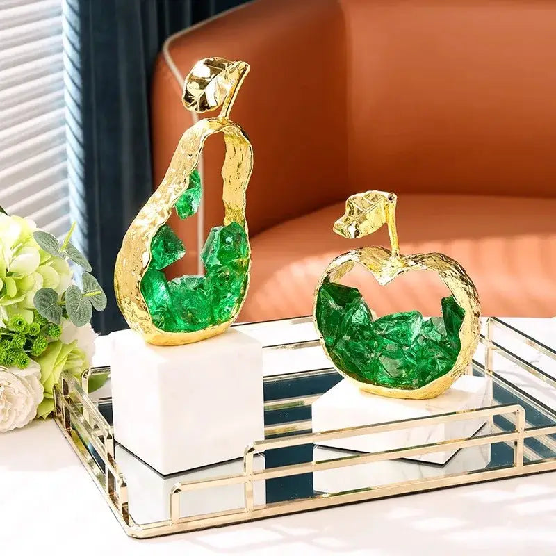 Modern gold crystal metal fruit sculpture set featuring golden pear and apple with green crystal interiors on marble decorbites crystal metal bases