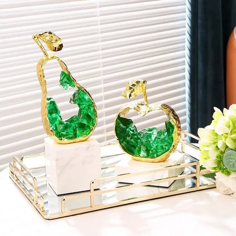 Modern gold crystal metal fruit sculpture set featuring golden-framed pear and apple decorbites crystal metal sculptures with green interiors on marble bases