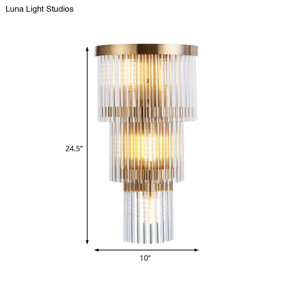 Modern gold crystal rod tiered wall lamp with three cascading levels of clear glass rods in a brushed brass frame