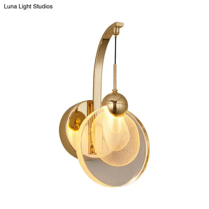 Modern gold wall lamp with curved metal arm and illuminated frosted crystal shade suitable for 110v-120v and 220v-240v use