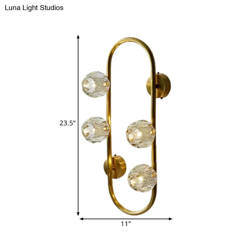 Modern gold wall lamp with crystal shade and four faceted globe bulbs in a direct wired electric design