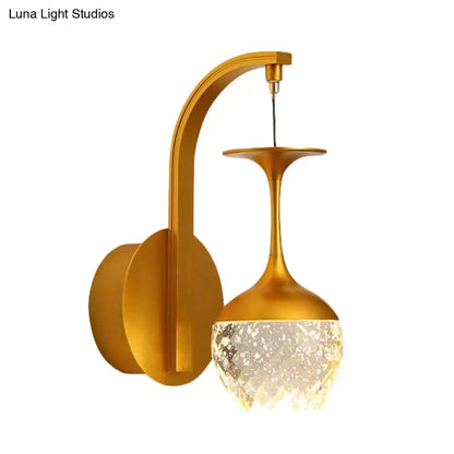 Modern gold wall light featuring an inverted wine glass design with a textured translucent crystal shade for bedrooms