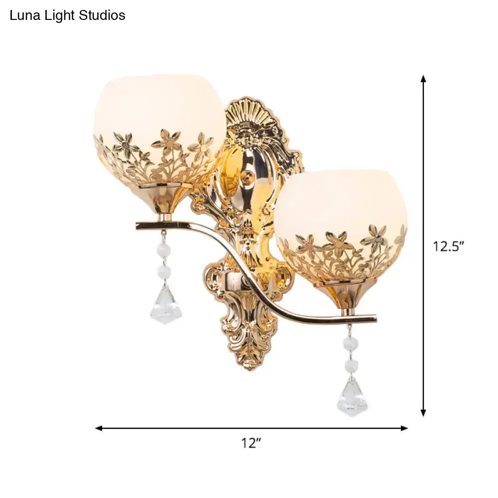 Modern gold sconce light fixture with crystal shade featuring frosted glass floral cutouts and dangling teardrop pendants
