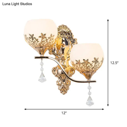 Modern gold sconce light fixture with crystal shade featuring frosted glass floral cutouts and dangling teardrop pendants