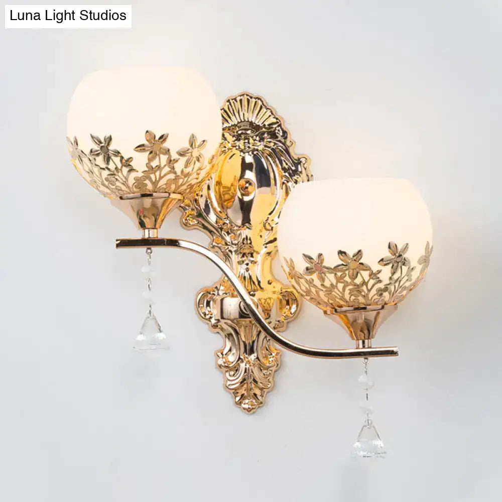 Modern gold sconce light fixture with crystal shade featuring frosted glass floral cutouts and dangling crystals