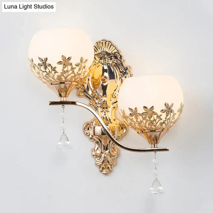Modern gold sconce light fixture with crystal shade featuring frosted glass floral cutouts and dangling crystals