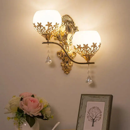 Modern gold sconce light fixture with crystal shade, frosted glass floral cutouts, and dangling crystal teardrops wall lamp
