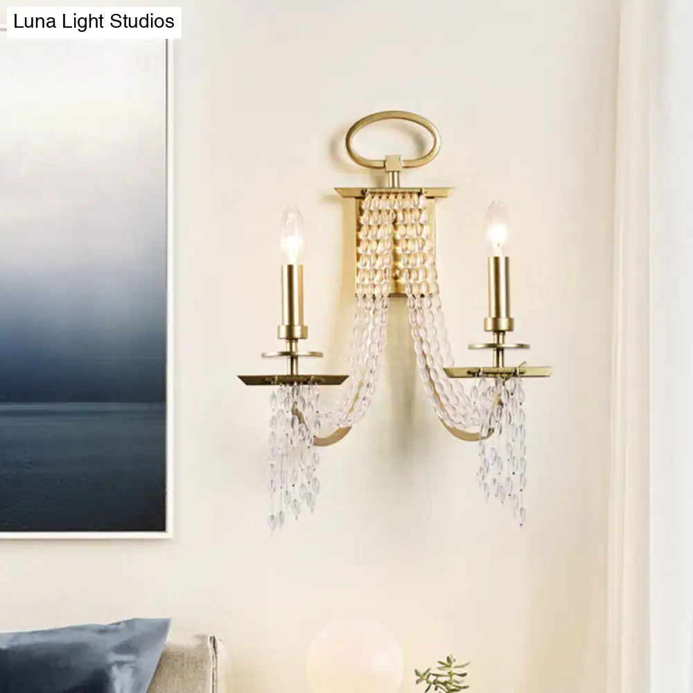 Modern gold crystal strand wall mounted candle sconce with two lights and cascading crystal beads for bedroom lighting