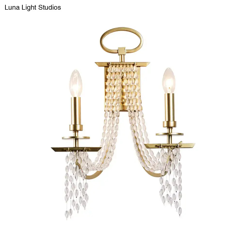 Modern gold crystal strand wall mounted candle sconce with two bulbs and cascading faceted crystal beads for bedroom light