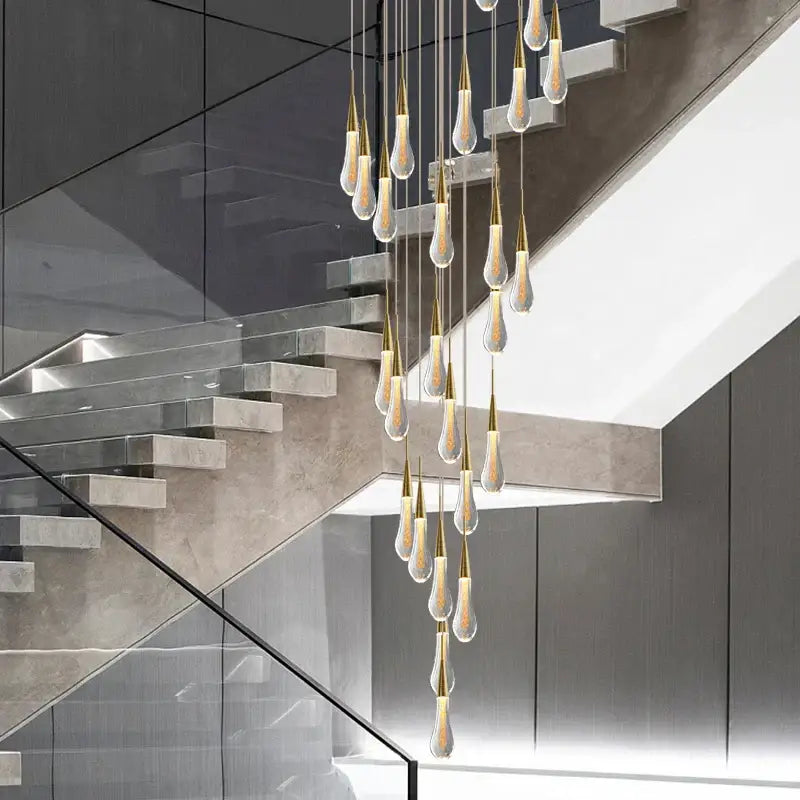 Modern gold crystal tear drop chandelier with multiple teardrop glass pendants suspended by gold-toned metal fixtures