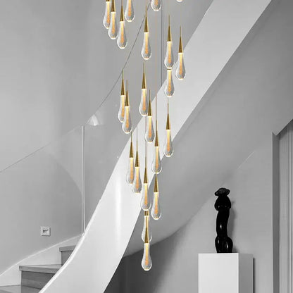 A modern gold crystal tear drop chandelier with multiple teardrop glass pendants and warm light for staircase decorbites crystal tear