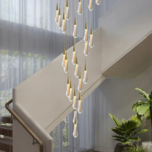 Modern gold crystal tear drop chandelier with teardrop glass pendants and gold-toned metallic tops illuminated within