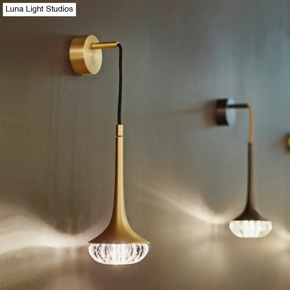Modern gold crystal wall lamp with gold-toned curved arm and faceted crystal glass shade for bedroom lighting