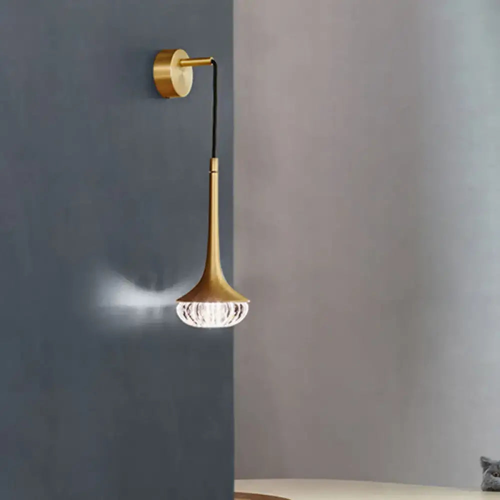 Modern gold crystal teardrop wall lamp with a gold-toned slender trumpet stem and faceted crystal shade for bedroom use