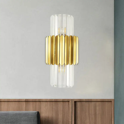 Modern gold crystal wall lamp with clear glass cylinder and gold-toned metallic slats for bedroom sconce lighting