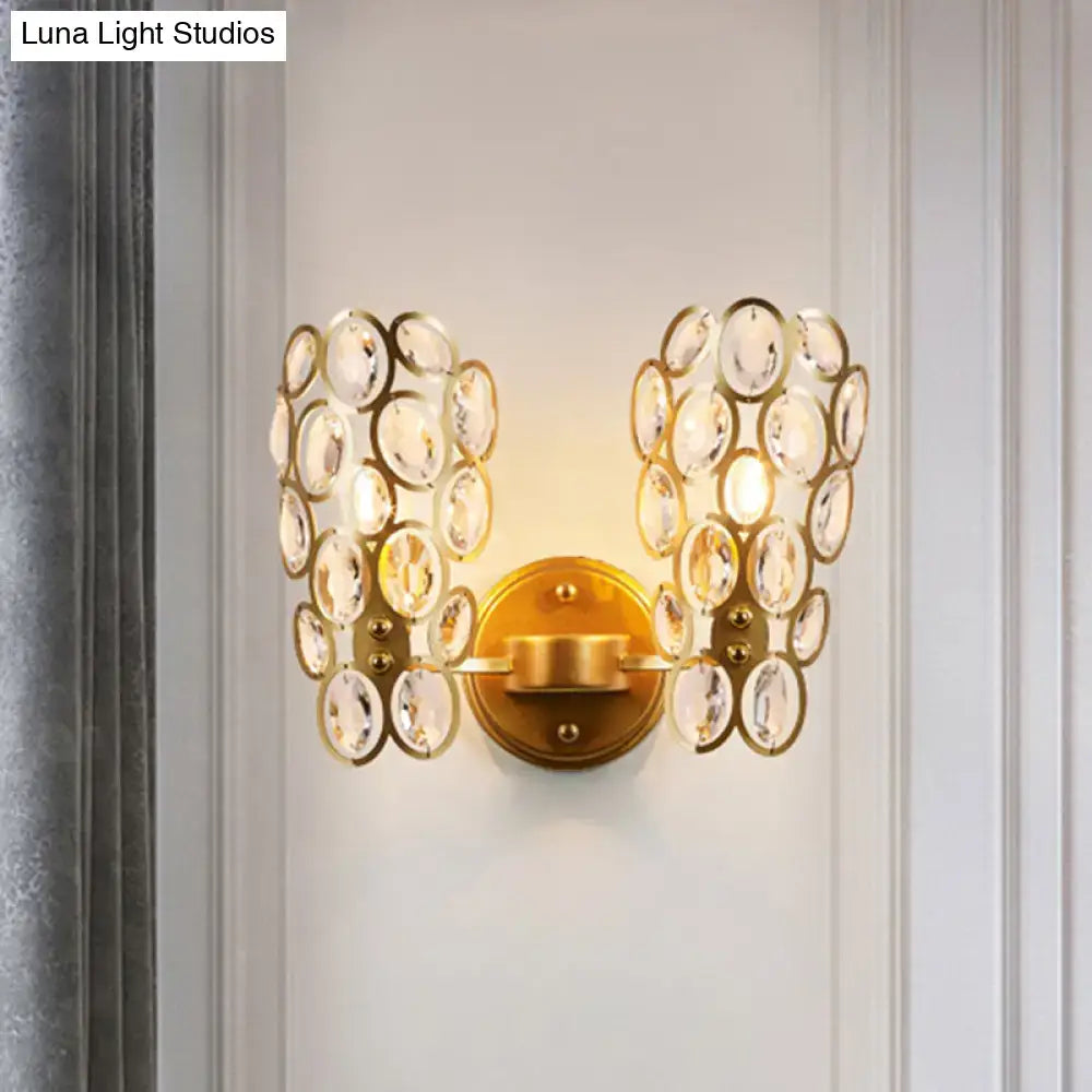 Modern gold crystal wall lamp featuring cascading clear crystal discs in symmetrical wing-like formations for bedroom sconce