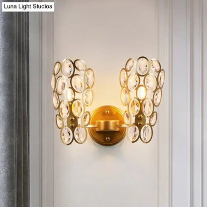 Modern gold crystal wall lamp featuring cascading clear crystal discs in symmetrical wing-like formations for bedroom sconce