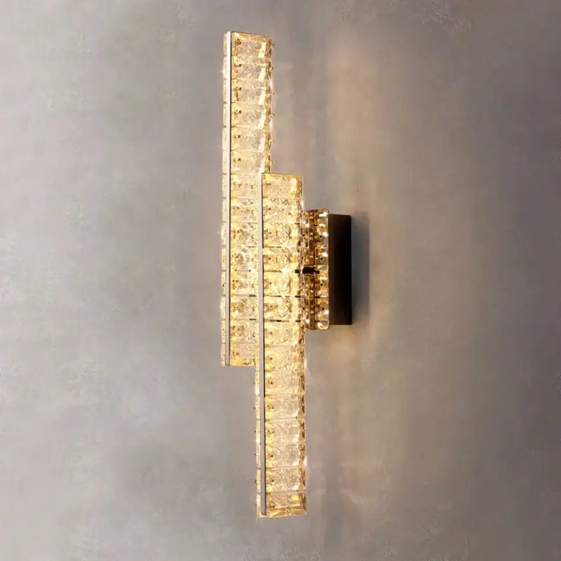 Modern gold crystal wall lamp with stacked clear faceted crystal tiers refracting warm light for elegant decorbites lighting