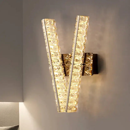 Modern gold wall lamp with v-shaped clear crystal strips in a sleek metallic frame for elegant living room decorbites crystal wall lighting