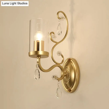 Modern gold wall light with clear glass cylinder shade and crystal droplets for bedroom lighting