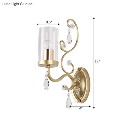 Modern gold wall light with clear crystal teardrop accents and a clear glass cylinder shade for bedroom use