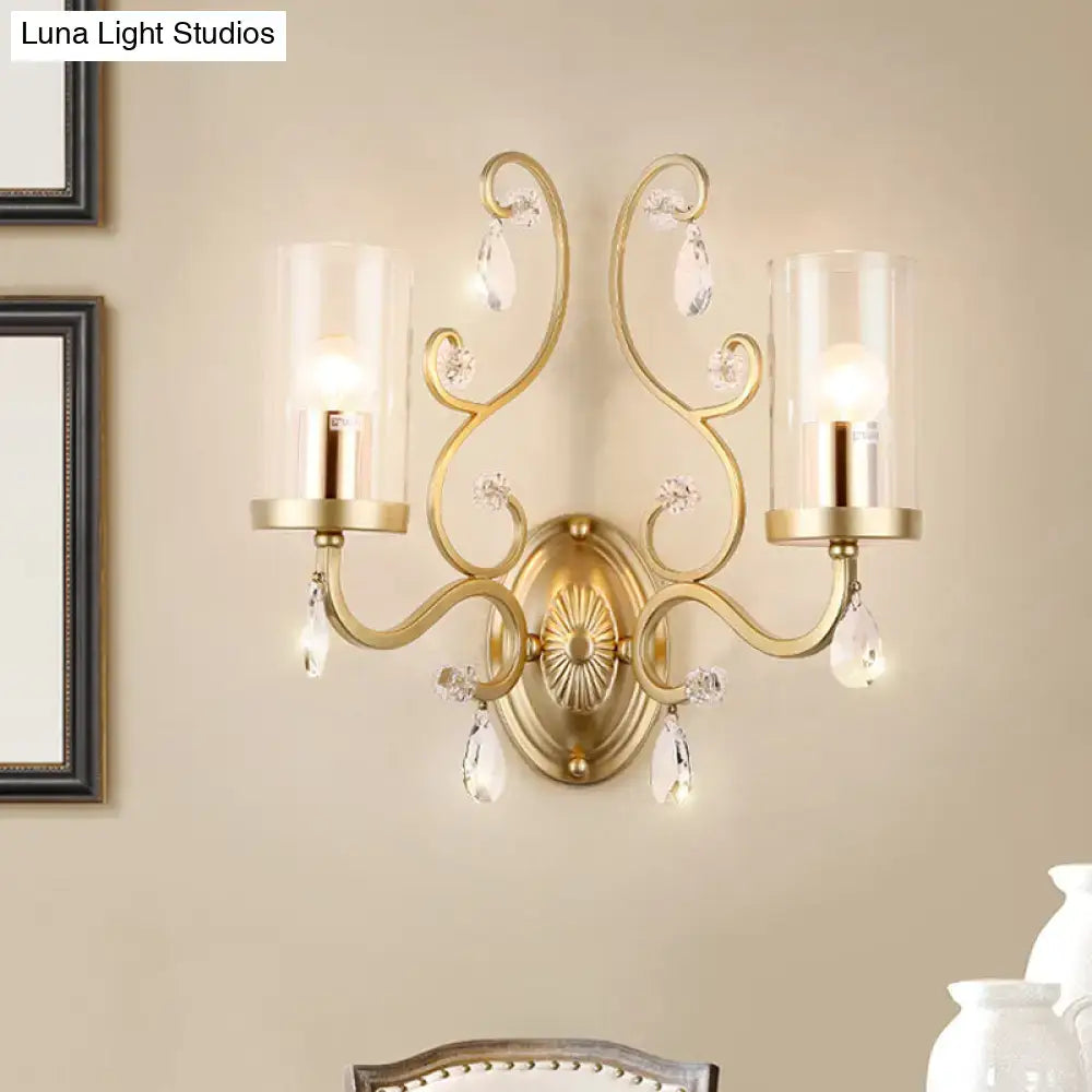 Modern gold crystal wall light featuring a clear glass cylinder shade and ornate crystal droplets for bedroom decor